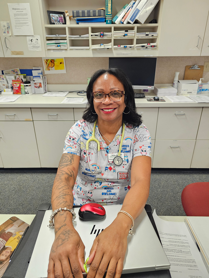 Picture of a nurse with tattoos at her desk